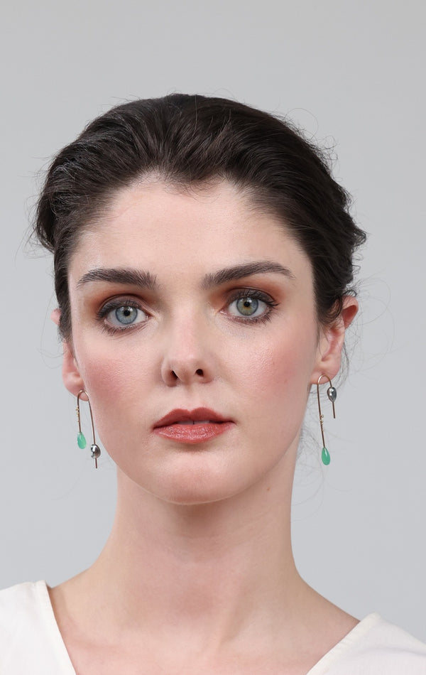 Woman wearing earrings against a plain background
